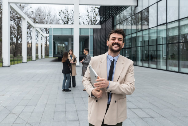 年轻的商人在办公楼前欢迎新员工，带他们去上班。曼恩欢迎外国公司代表团参加研讨会和发展会议图片下载