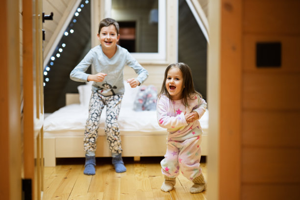 孩子们穿着柔软温暖的睡衣在木屋里玩耍。童年的概念，休闲活动，幸福。哥哥和妹妹在一起玩得很开心。图片下载