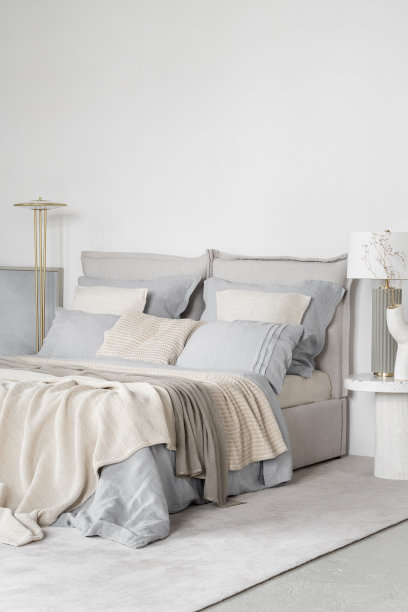 舒适的床在明亮的卧室在蓝色和米色图片下载