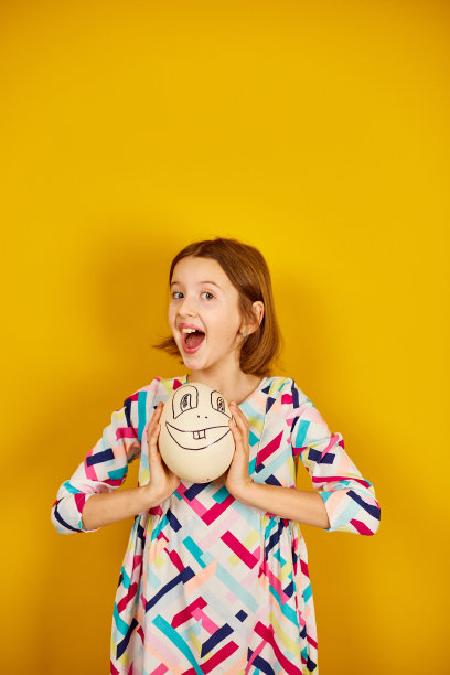 快乐顽皮的少年女孩抱着滑稽的鸵鸟蛋图片下载