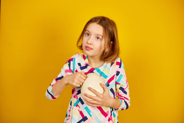 快乐顽皮的少年女孩抱着鸵鸟蛋图片下载