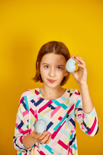 快乐俏皮的少年女孩与彩绘复活节彩蛋图片下载