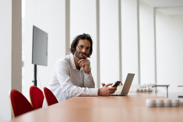 年轻的商人、经理或办公室职员坐在大会议室的笔记本电脑前图片下载