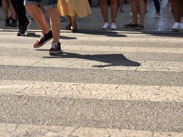 许多人走在波尔图市中心。行人在波尔图市中心的人行横道上穿过繁忙的街道，葡萄牙图片下载
