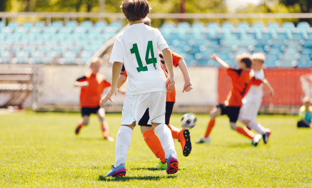 小男孩在踢足球。快乐的孩子们在足球比赛中竞争。孩子们在运动中获得乐趣。奔跑的足球运动员。足球运动员之间的比赛图片下载