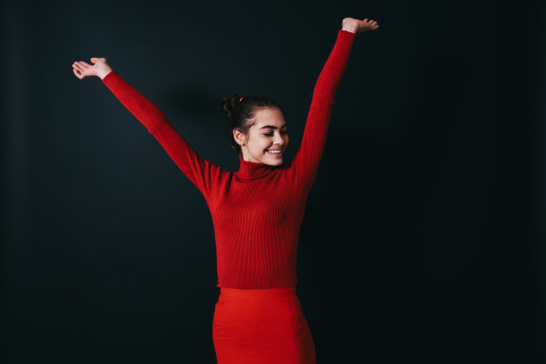 兴奋的女人举起手在工作室图片下载