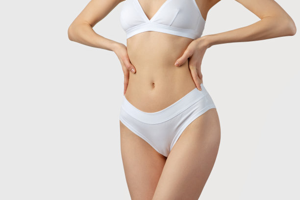 年轻苗条的女人在白色内衣的灰色背景图片下载