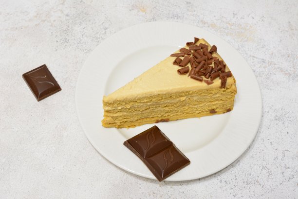 一块蜂蜜蛋糕，巧克力片和巧克力块放在盘子里图片下载