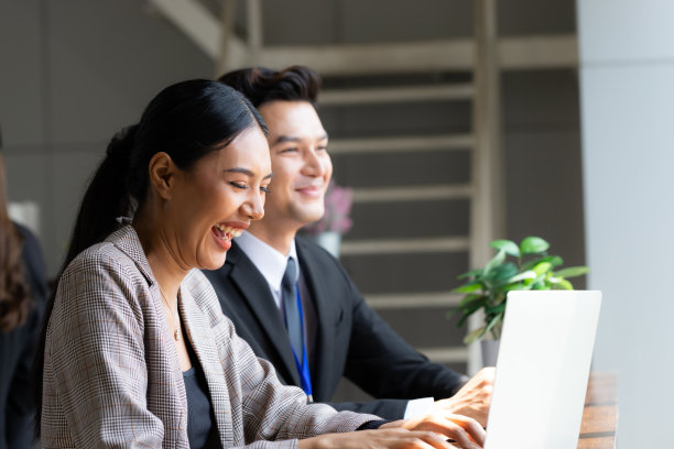 女商人看起来很开心，她坐着和老板讨论，桌上放着咖啡和电脑，到处都是概念工作，在家工作。图片下载