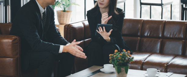 女商人用平板电脑上的信息与老板讨论，喝咖啡，到处概念工作，在家工作。图片下载