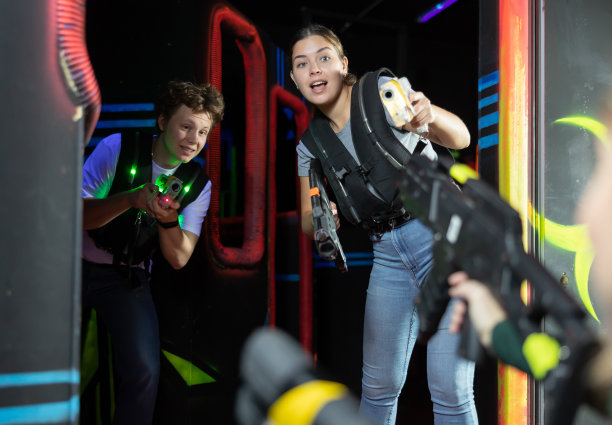 男孩和女孩在玩激光枪战时又跑又躲图片下载