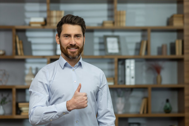 画像一个年轻英俊的成功人士商人，律师在办公室，看着相机图片下载