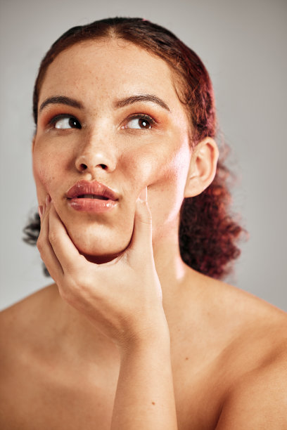 美丽，自然和真实的脸的工作室妇女与化妆品，彩妆和健康的皮肤护理发光。皮肤病学，水疗沙龙和模特女孩抓脸颊面部按摩隔离在灰色背景图片下载