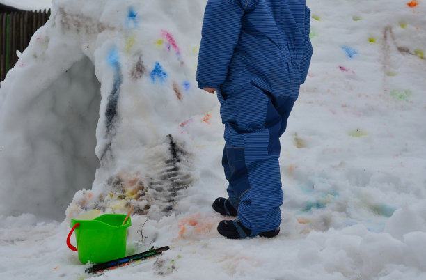冬季艺术教育也可以在雪地里进行。可以用水彩在冰屋上画点。雪融化了，彩色斑点融化并伸展开来。儿童和学龄前儿童用画笔画画图片下载