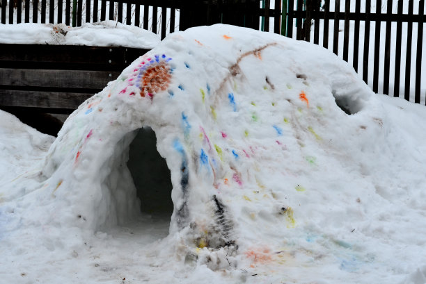 冬季艺术教育也可以在雪地里进行。可以用水彩在冰屋上画点。雪融化了，彩色斑点融化并伸展开来。儿童和学龄前儿童用画笔画画图片下载