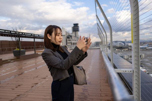 商务女士在机场观景台拍照图片下载