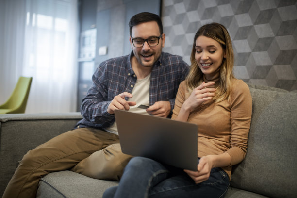 夫妻在客厅使用笔记本电脑图片下载