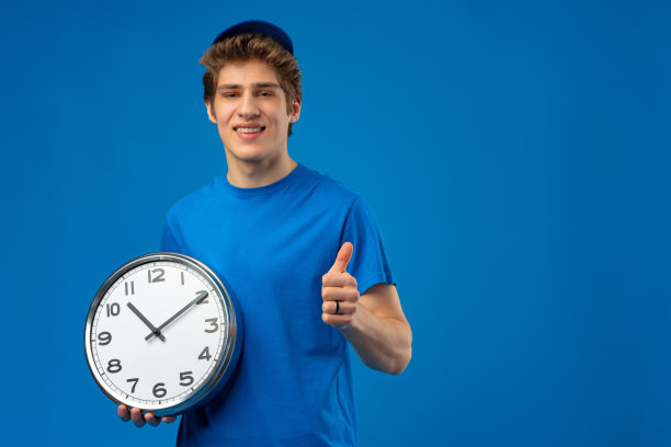 送货员拿着蓝色背景的时钟。图片下载