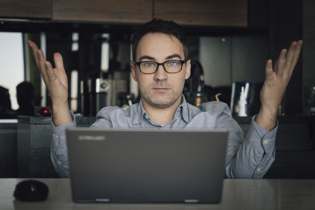 愤怒易怒的戴眼镜年轻人，经纪人，商人或经理，得到了经济损失，交易破裂，不高兴地看着镜头，用手比划着图片下载