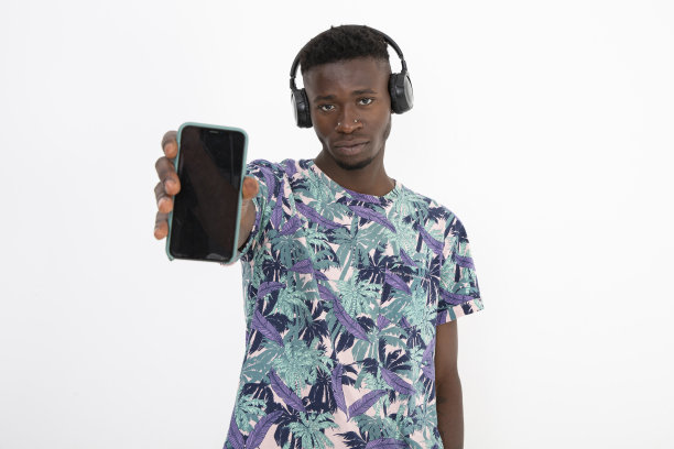 年轻的非洲裔黑人男子穿着有图案的彩色t恤，戴着耳机，做出不同的面部表情。图片下载