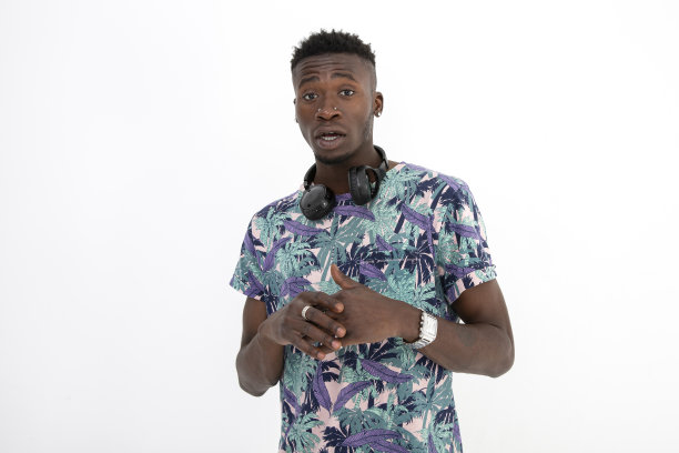 年轻的非洲裔黑人男子穿着有图案的彩色t恤，戴着耳机，做出不同的面部表情。图片下载