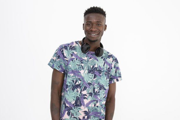 年轻的非洲裔黑人男子穿着有图案的彩色t恤，戴着耳机，做出不同的面部表情。图片下载