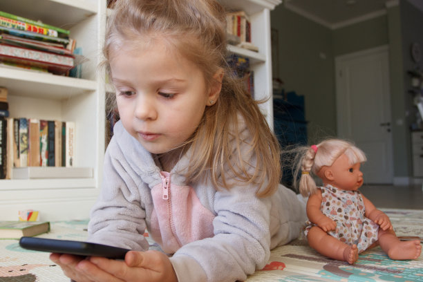 可爱的小孩拿着绿色屏幕的智能手机。在线教育的概念图片下载