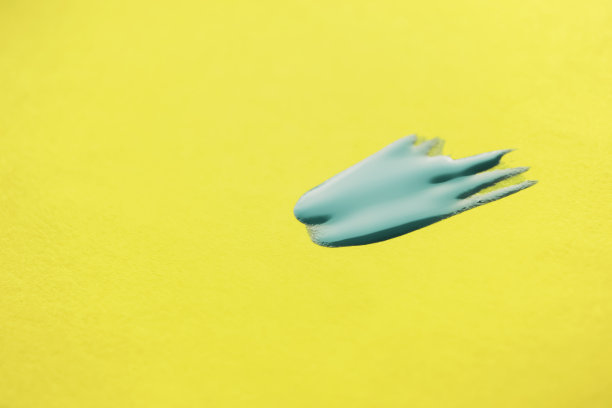 黄色的背景是蓝色的指甲油。黄色底色上的一点蓝色清漆。图片下载