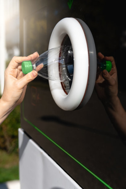 一名妇女使用自动售货机接收用过的塑料瓶图片下载