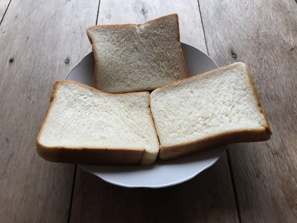 面包在木质背景上。乡村黑麦。新鲜的面包的乡村传统的木质纹理背景。面包店有硬皮面包。烘焙产品标签、设计等设计元素图片下载