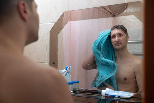 男人洗完澡后用毛巾擦湿了头发。图片下载