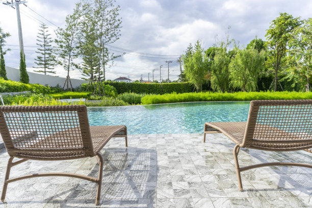 在游泳池里的木地板上放着木制沙发床，有蓝天。图片下载