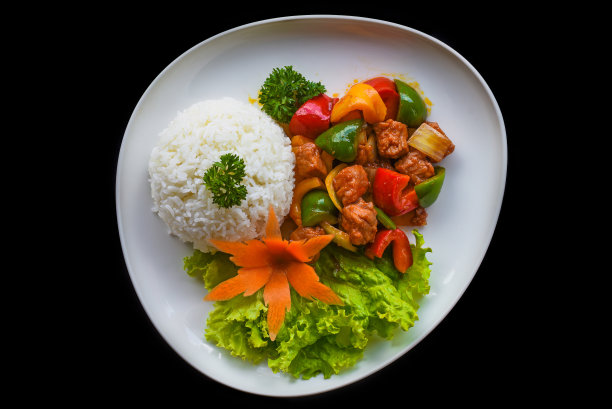 青菜炖牛肉和米饭放在蓝色盘子上，黑色背景俯视图图片下载