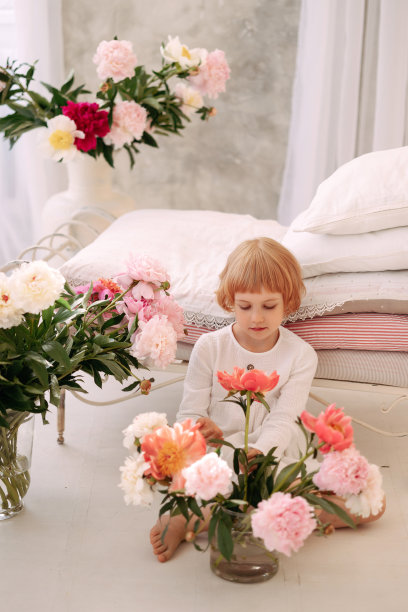 一个6-7岁的女孩穿着白色的裙子，手里拿着一朵花图片下载