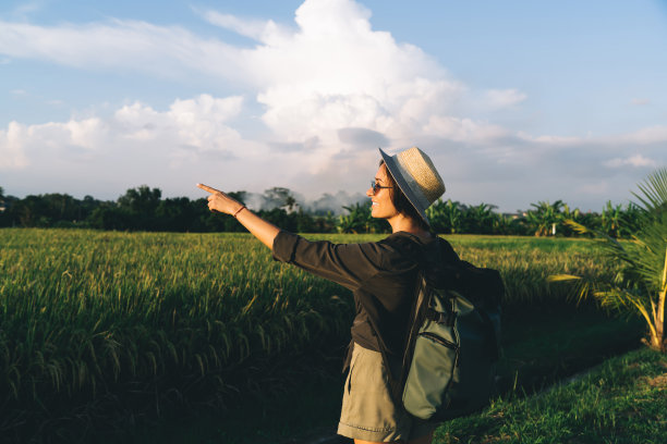 年轻的女性背包客正在欣赏绿色稻田的自然图片下载