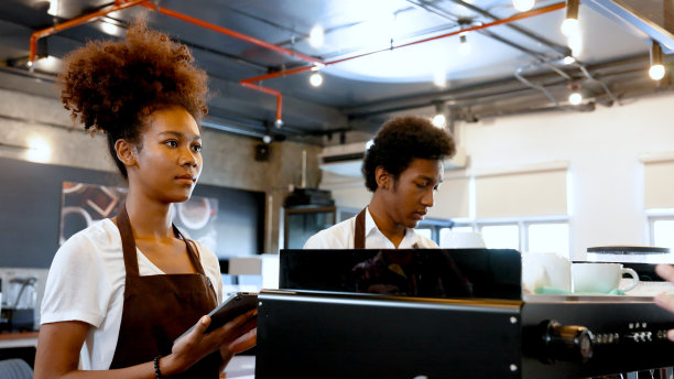 学生来昌凯实习当咖啡师，女学生聚精会神地听老师讲了什么，故意写下名字装置专门命名为咖啡机的老师告诉。图片下载