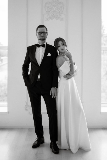 新郎系着黑色西装领带，新娘在明亮的画室里图片下载