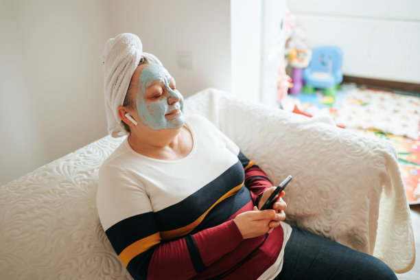 真实的客厅时刻女性享受护肤和音乐图片下载