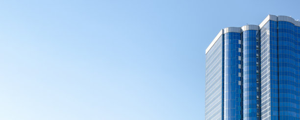 蓝色玻璃幕墙衬托蓝天的高层建筑。多层现代住宅建筑图片下载
