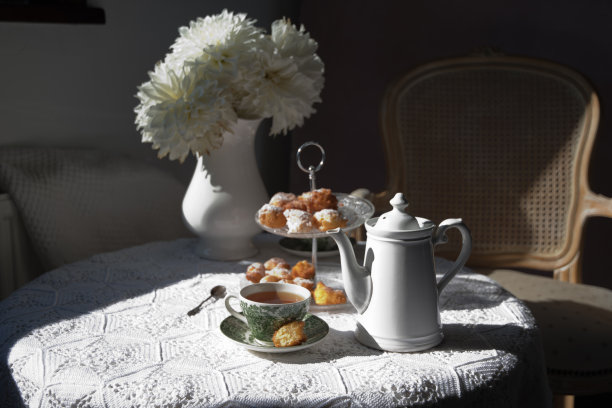 英伦风格的茶歇，复古的静物，自制的小面包和一束白色黛丽图片下载