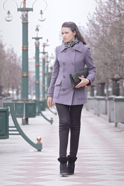 现代的年轻女子走在秋日的城市街道上图片下载