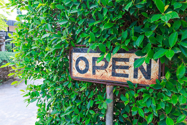 在咖啡馆里，一个老式的白色金属板上写着“开”。图片下载
