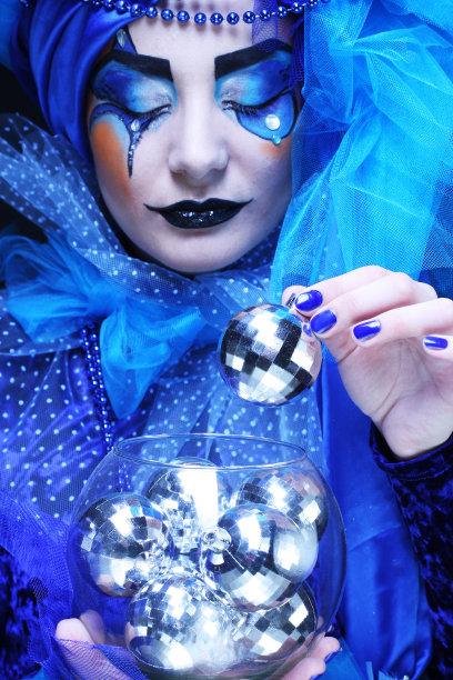 年轻美丽的女人与创造性的面孔和服装在黑色背景。关闭了。图片下载