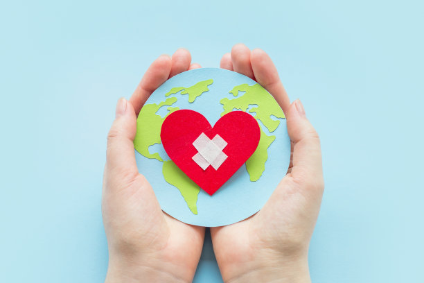 世界心脏病学家日。健康日概念。女性的手拿着一个带心形的纸质地球仪模型图片下载
