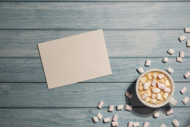 空白的问候或邀请卡片模拟白色的咖啡杯和棉花糖在木制的蓝色背景。空白纸复制空间的文本。情人节，父亲母亲节快乐，妇女节放假图片下载