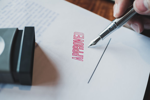 商务人员在批准的合同表格上盖章。公证盖章文件。图片下载