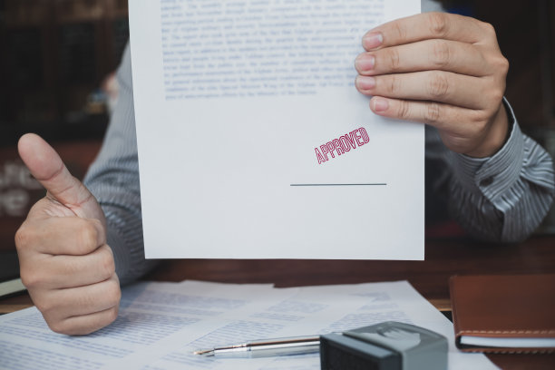 商务人员在批准的合同表格上盖章。公证盖章文件。图片下载