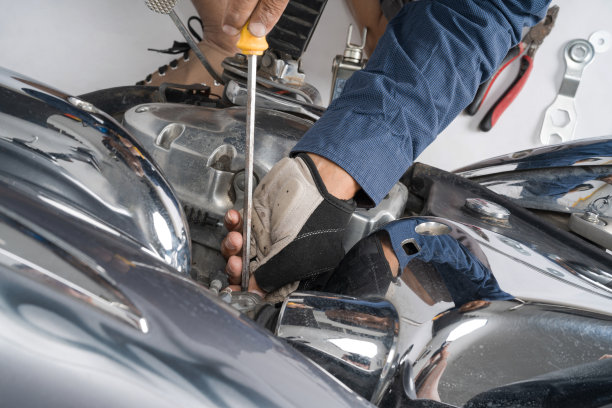 人们正在修理摩托车，使用扳手和螺丝刀来工作图片下载