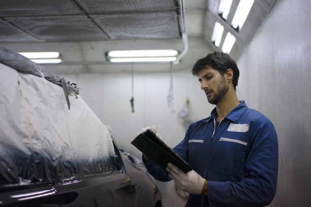 年轻企业家在汽车修理厂工作。图片下载