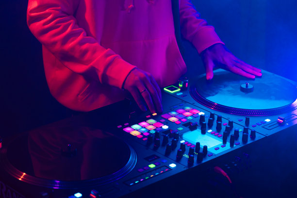 一个DJ的手创造和调节音乐在DJ控制台混频器在俱乐部音乐会图片下载